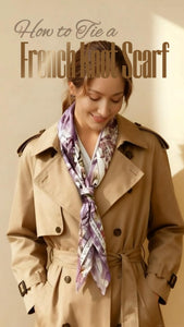 Woman wearing a beige trench coat with a floral scarf, demonstrating how to tie a French knot scarf.